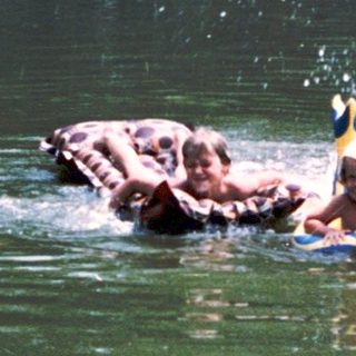Elephant and trainer playing in water.