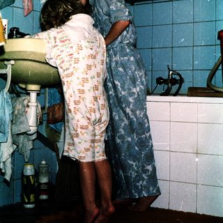 Two people hugging in a bathroom.