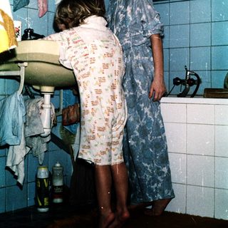 Two children brushing teeth in bathroom.