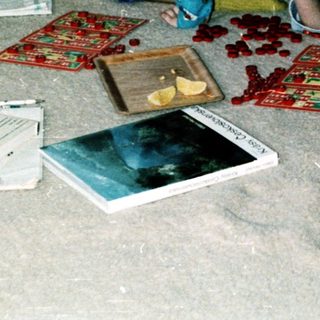 Two children playing with cards on bed.