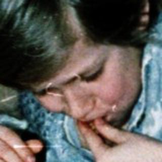 Two children playing with cards on bed.