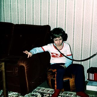 Young person listening to cassette tapes with headphones.