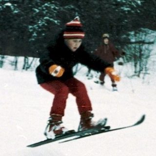 People skiing and snowboarding on snowy slope.
