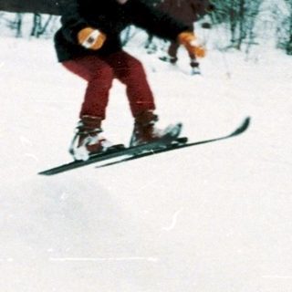 People skiing and snowboarding on snowy slope.