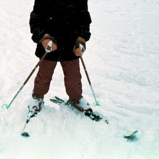 Two children skiing in snowy outdoor setting.