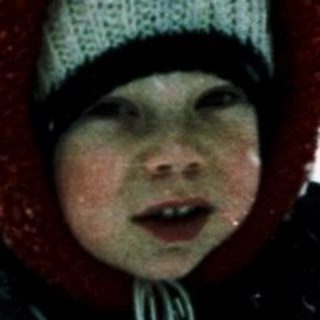 Child playing in snow-covered outdoor setting.