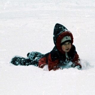 Child playing in snow-covered field.