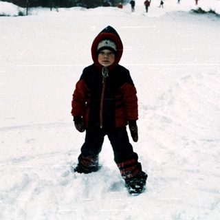Child skiing on snow-covered slope.