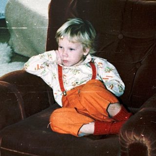 Child sitting in armchair during indoor snow play.