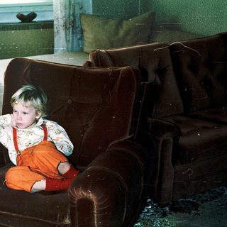 Child sitting in armchair during indoor snow play.