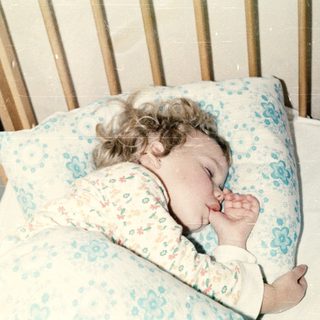 A baby peacefully sleeping in a crib.