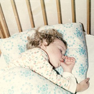 A baby peacefully sleeping in a crib.