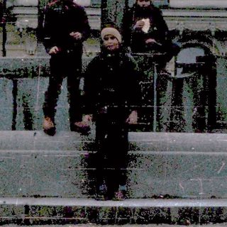 Children playing near a historic fountain in winter.