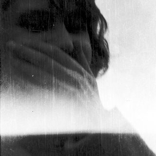 Blurred close-up of person under falling water.
