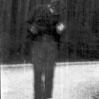 Silhouette of person ice skating in rain.