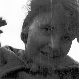 Person smiling while standing in rain.