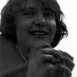 Person laughing under falling rain or shower.