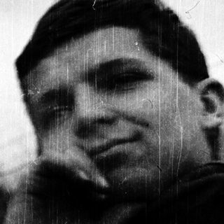 Young man in vintage military uniform outdoors.