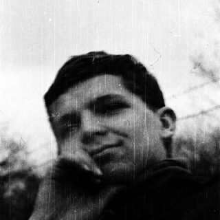 Young man in vintage military uniform outdoors.
