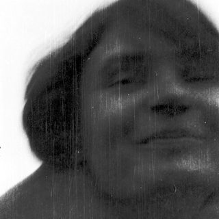 Person standing in rain with blurred face.