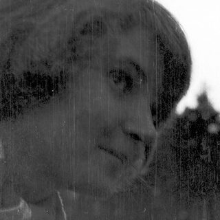 Silhouette of person in rain through window.