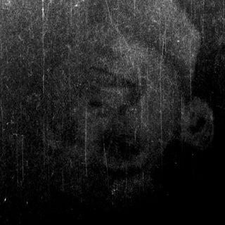 Man smiling under rain with "Vans" logo visible.