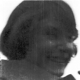 Silhouette of person with hat, blurred rain streaks.