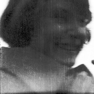 Silhouette of person with hat, blurred rain streaks.