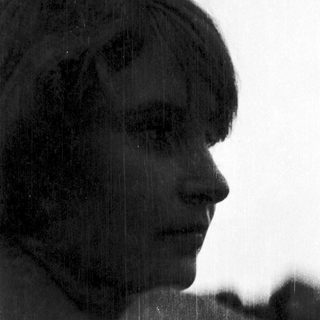 Silhouette of person against rain-soaked window.