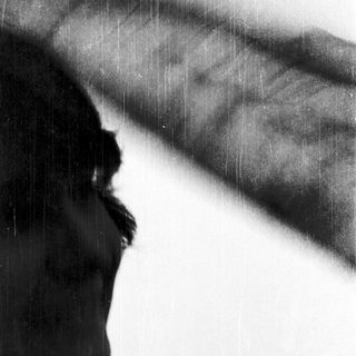 Silhouette of person looking upward in rain.