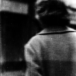 Blurred view of person sitting near window.