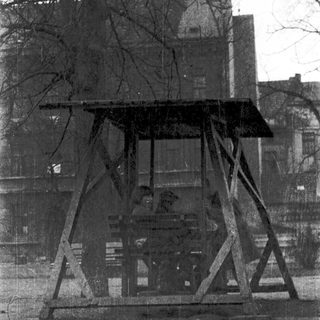Vintage outdoor wooden swing set with metal frame.
