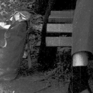 Young man sitting outdoors, sketching on a bench.