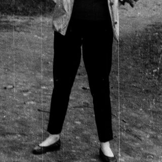 Person standing outdoors in a park-like setting.