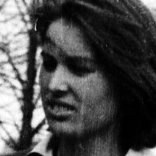 Young woman in 1960s-style outfit standing outdoors.