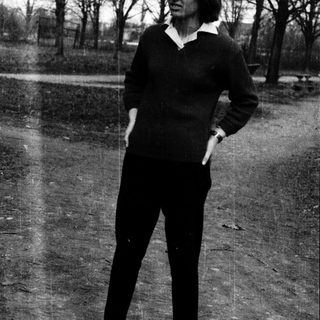 Young woman in 1960s-style outfit standing outdoors.