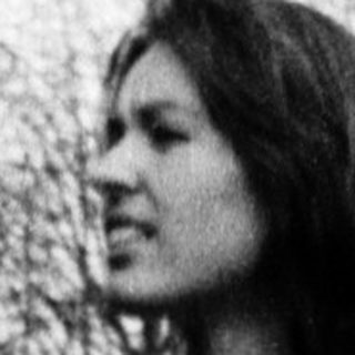 Woman standing outdoors in casual attire.