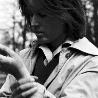 Young person smoking outdoors in natural setting.