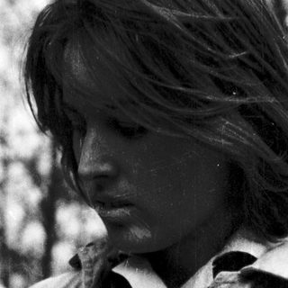 Young person smoking outdoors in natural setting.