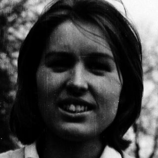 Smiling woman outdoors in vintage-style photograph.