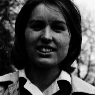 Smiling woman outdoors in vintage-style photograph.