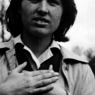 Young woman clapping hands outdoors.