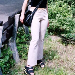 Woman standing by fence in park area.