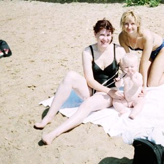 Family beach outing with children in sand.