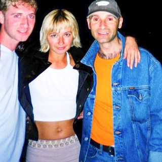 Four people posing together outdoors at night.