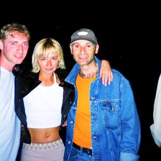 Four people posing together outdoors at night.