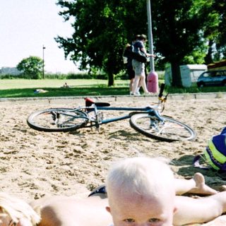 Family enjoying outdoor beach day with sunbathing and play.