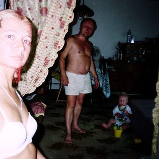 Family reflection in mirror, indoor setting.