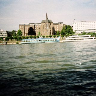 Waterfront view of historic buildings and river cruise boats.