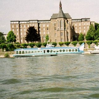 Waterfront view of historic buildings and river cruise boats.